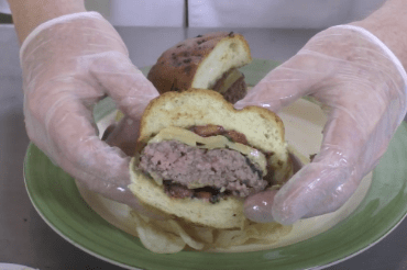 Person holding a half of a hamburger